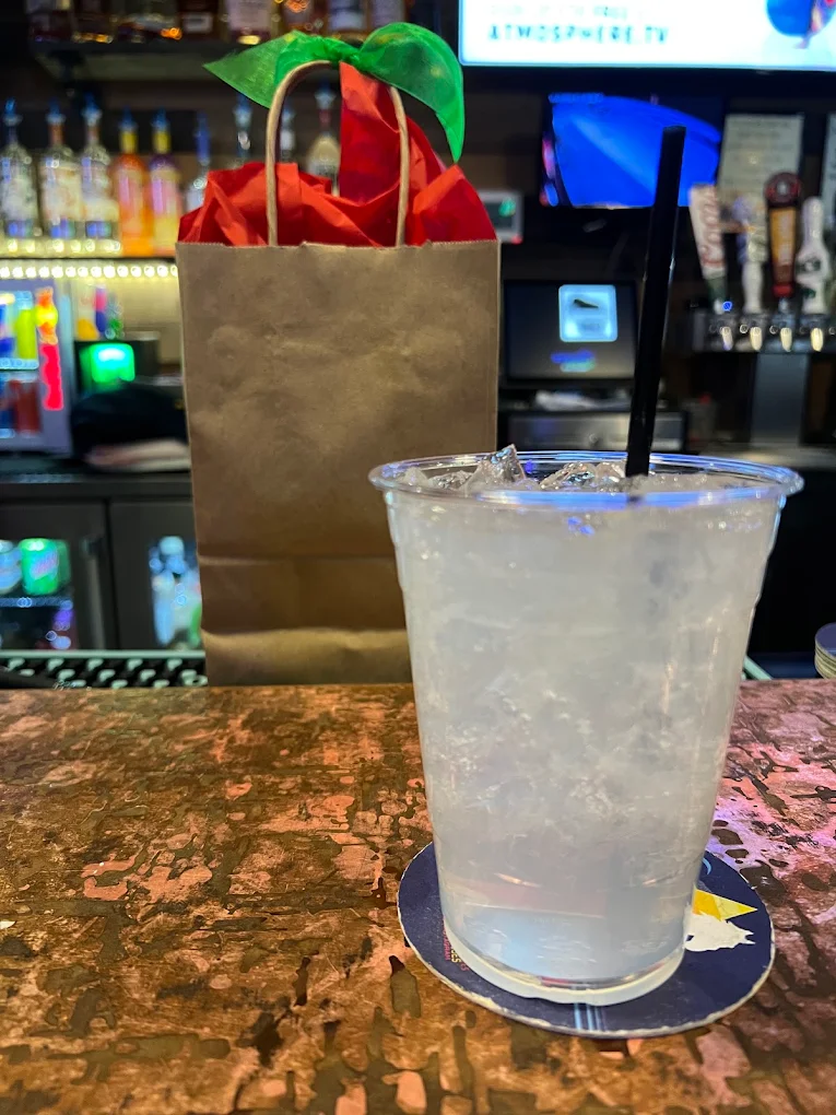 Iced highball on the bar next to a wrapped gift bag